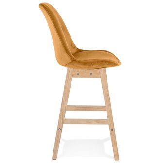Halfhoge kruk &#039;MORISS MINI&#039; in mosterd fluweel met poten in natuurlijk hout